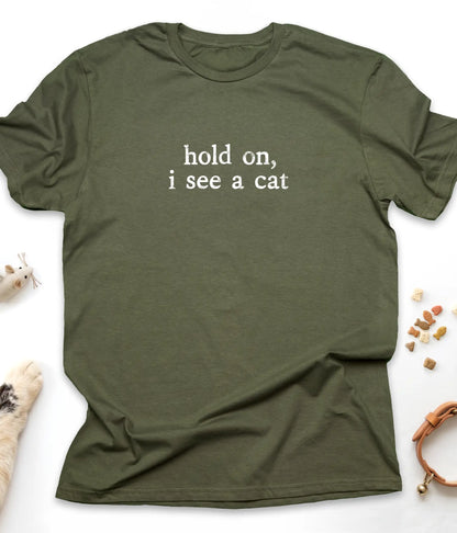 Military Green funny cat t-shirt with "Hold On, I See A Cat" design, flat lay top view
