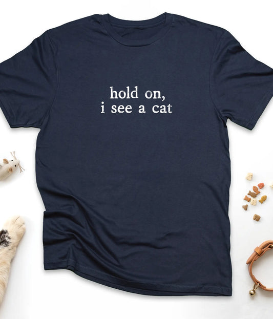 Navy funny cat t-shirt with "Hold On, I See A Cat" design, flat lay top view