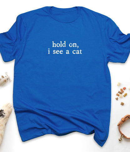 Royal funny cat t-shirt with "Hold On, I See A Cat" design, flat lay top view