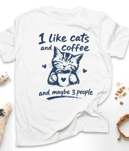 White funny cat t-shirt with "I Like Cats And Coffee And Maybe 3 People" design, flat lay top view