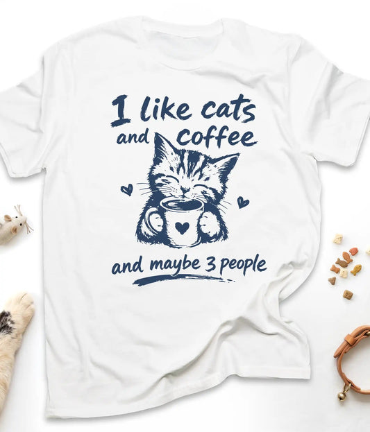White funny cat t-shirt with "I Like Cats And Coffee And Maybe 3 People" design, flat lay top view