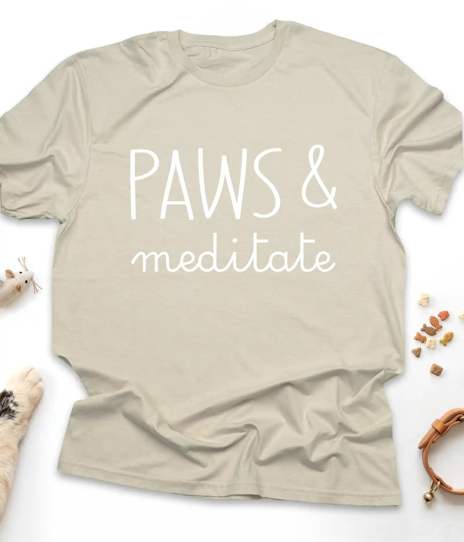 Sand funny cat t-shirt with "Paws & Meditate" design, flat lay top view