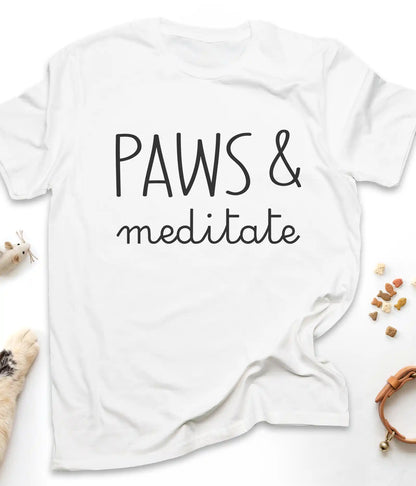 White funny cat t-shirt with "Paws & Meditate" design, flat lay top view