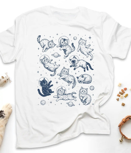 White funny cat t-shirt with astronaut kittens floating in space, flat lay top view