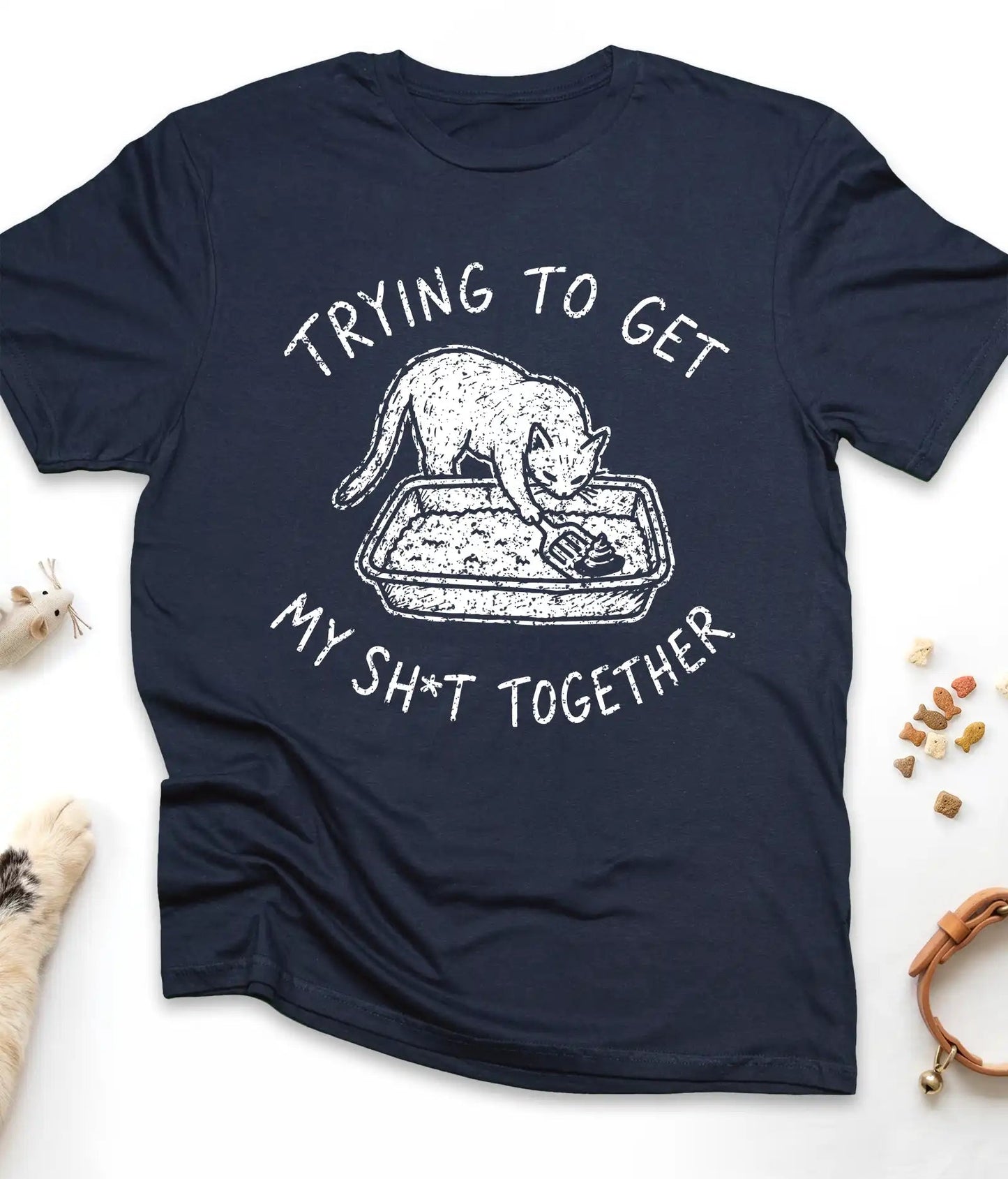 Navy funny cat t-shirt with "Trying To Get My Shit Together" litter box design, flat lay top view