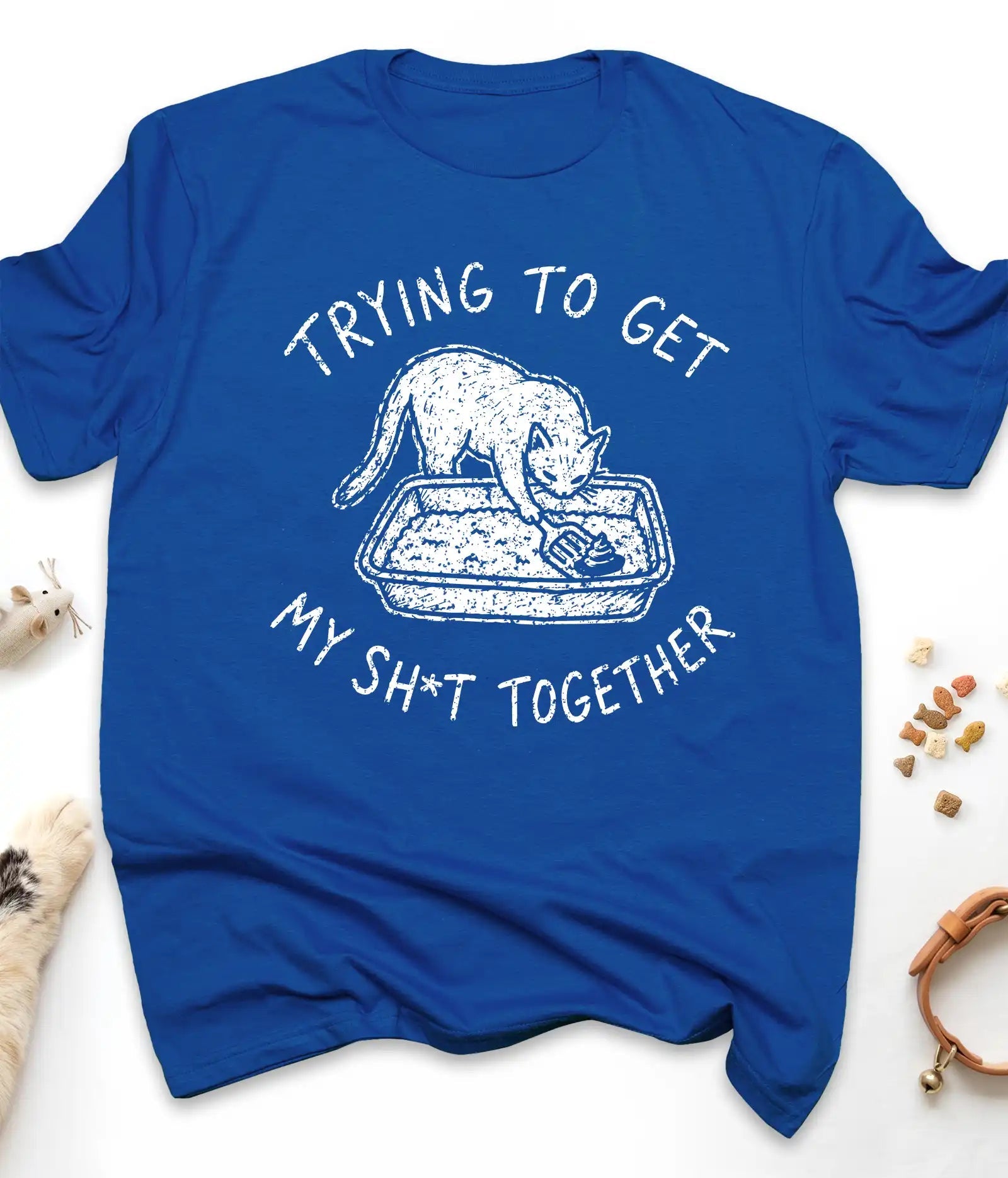 Royal funny cat t-shirt with "Trying To Get My Shit Together" litter box design, flat lay top view