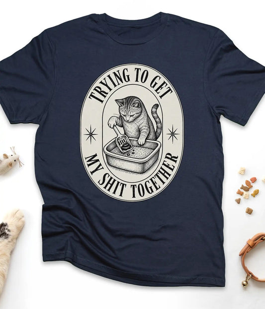 Navy funny cat t-shirt with a vintage "Trying To Get My Shit Together" litter box design, flat lay top view
